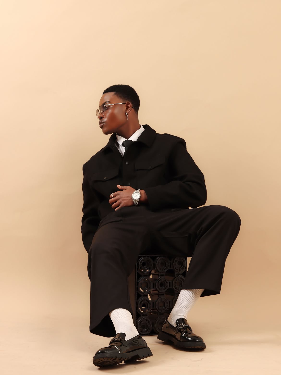 Study V: Grounded perspective — seated low on crate, athletic rib and patent loafers